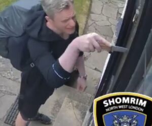 Man prying mezuzah off door