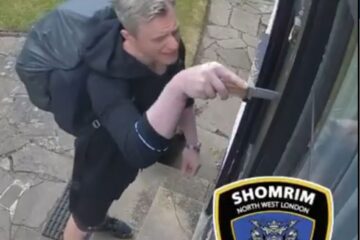 Man prying mezuzah off door