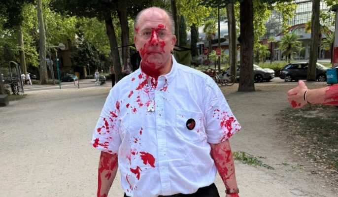 ‘Child killers’: Jewish activists doused with red paint in Germany while hanging up hostage posters