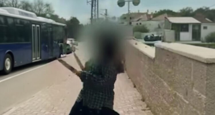 Woman brandishing knives moves through streets as missile sirens blare